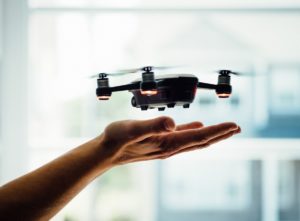 Fliegende Drohne über einer Hand (Drohnen Versicherung Österreich Airandmore)
